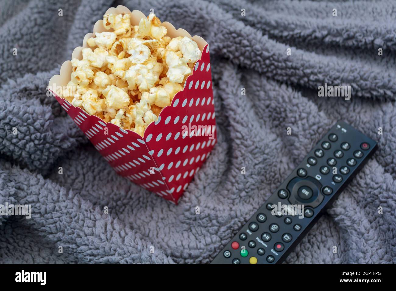 Caja de palomitas de maíz y mando a distancia para TV en manta de peluche  Fotografía de stock - Alamy