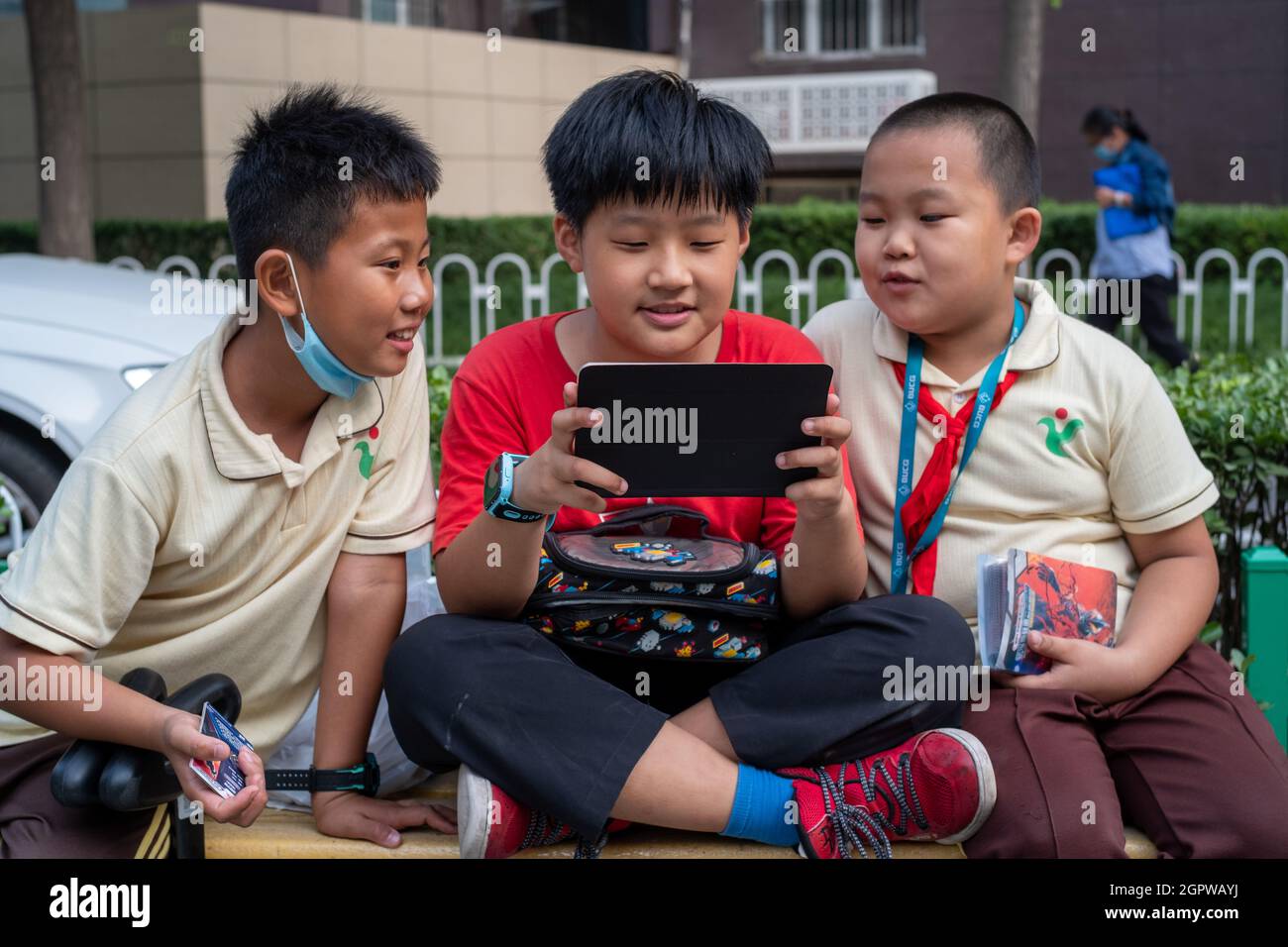 Los estudiantes chinos de la escuela primaria juegan videojuegos con un Pad después de la escuela en Beijing, China. 30-Sep-2021 Foto de stock
