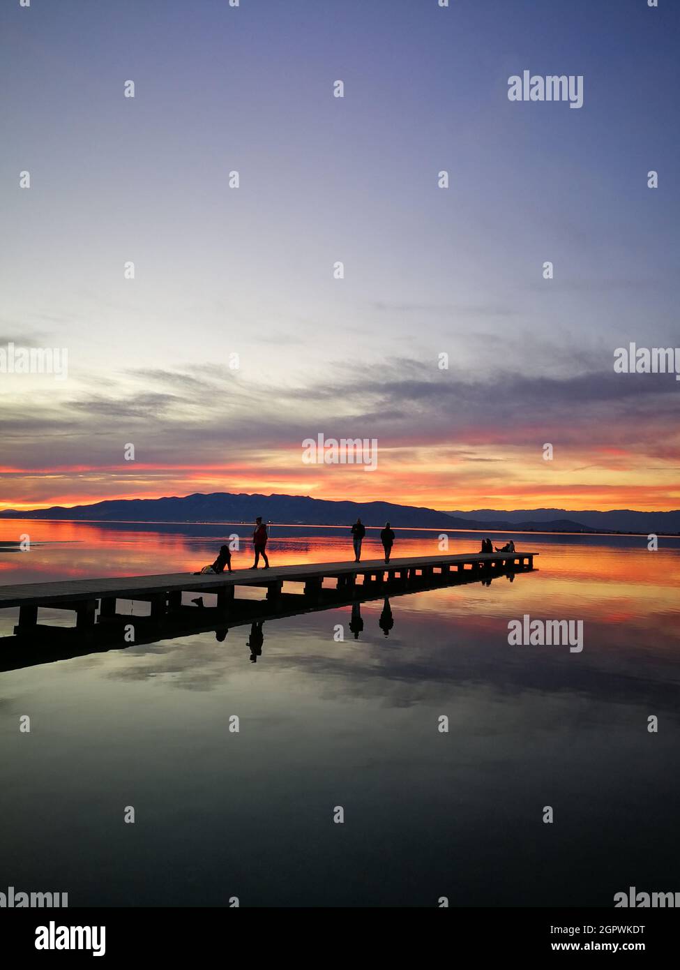 Silueta de personas sobre el lago contra el cielo durante la puesta de sol Foto de stock