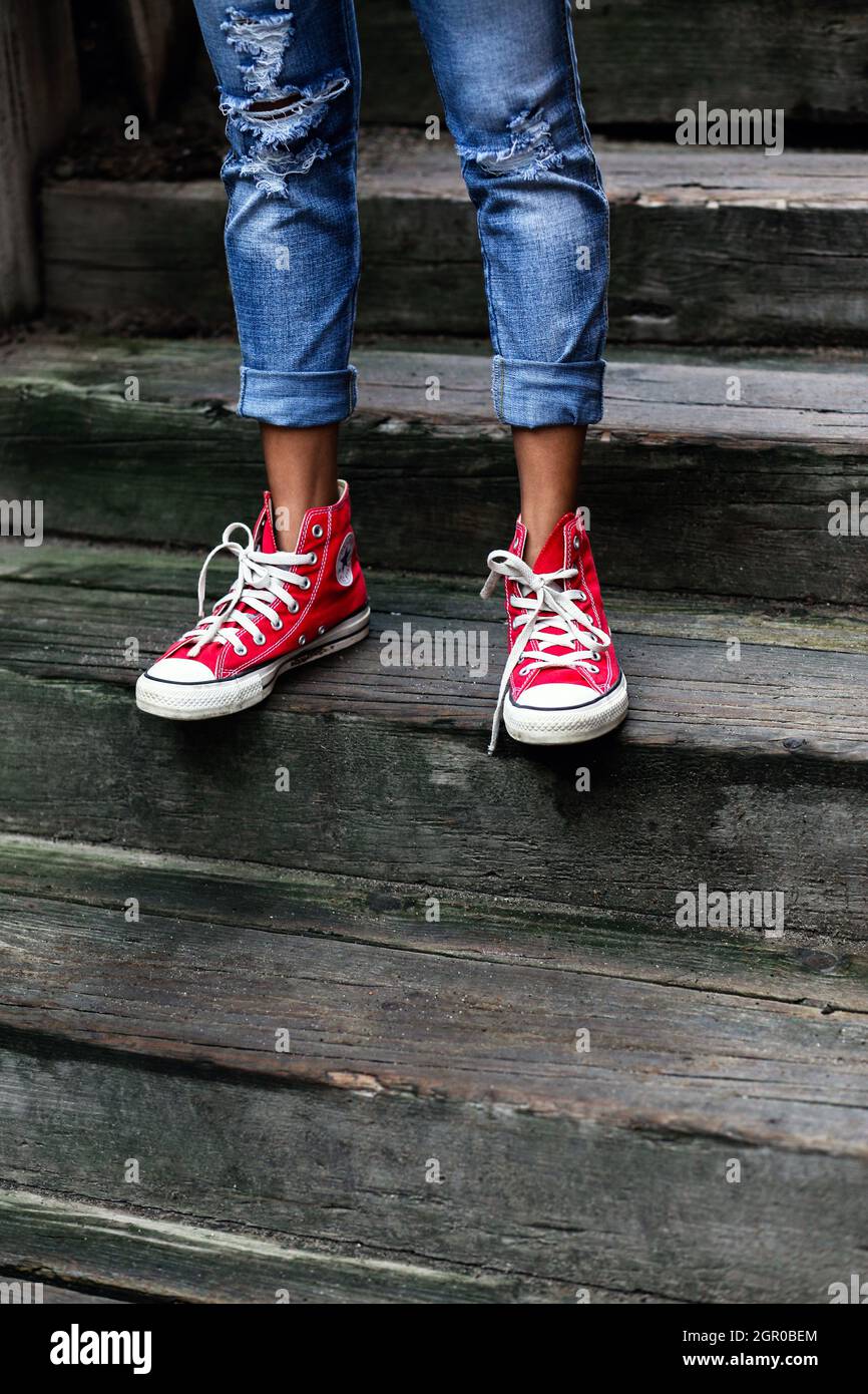 MINNEAPOLIS, ESTADOS UNIDOS - Jul 20, 2018: un primer plano de las piernas  de una mujer con jeans y sneakers rojas Fotografía de stock - Alamy