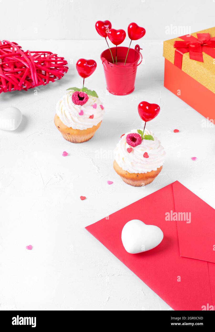 Composición del Día de San Valentín. Cupcakes con crema batida y corazón  Sprinkles, sobre y caja de regalo Fotografía de stock - Alamy
