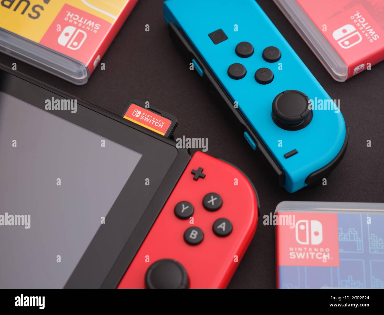 Tambov, Federación Rusa - 28 de septiembre de 2021 Nintendo Switch consola de video juego con un joy-con azul y cajas de video juego que se encuentran cerca. Foto de stock