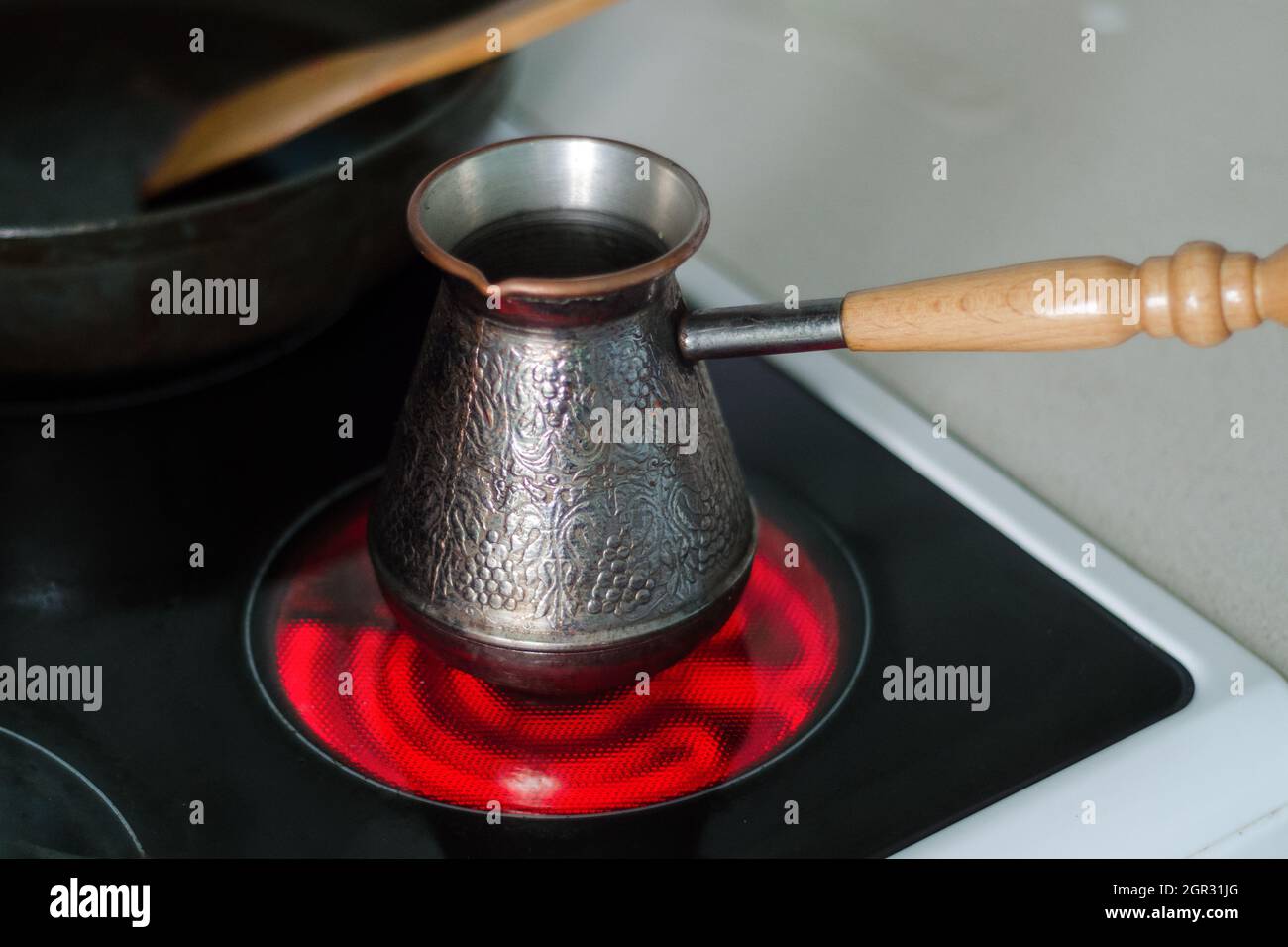 Hacer café en una turca de cobre en un horno eléctrico Fotografía de stock  - Alamy