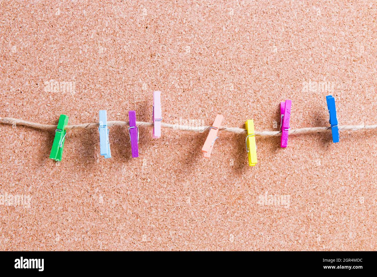 Cuántas pequeñas telas de papel de madera en Una cuerda contra un tablero  de corcho para notas, espacio de copia, maquetas Fotografía de stock - Alamy