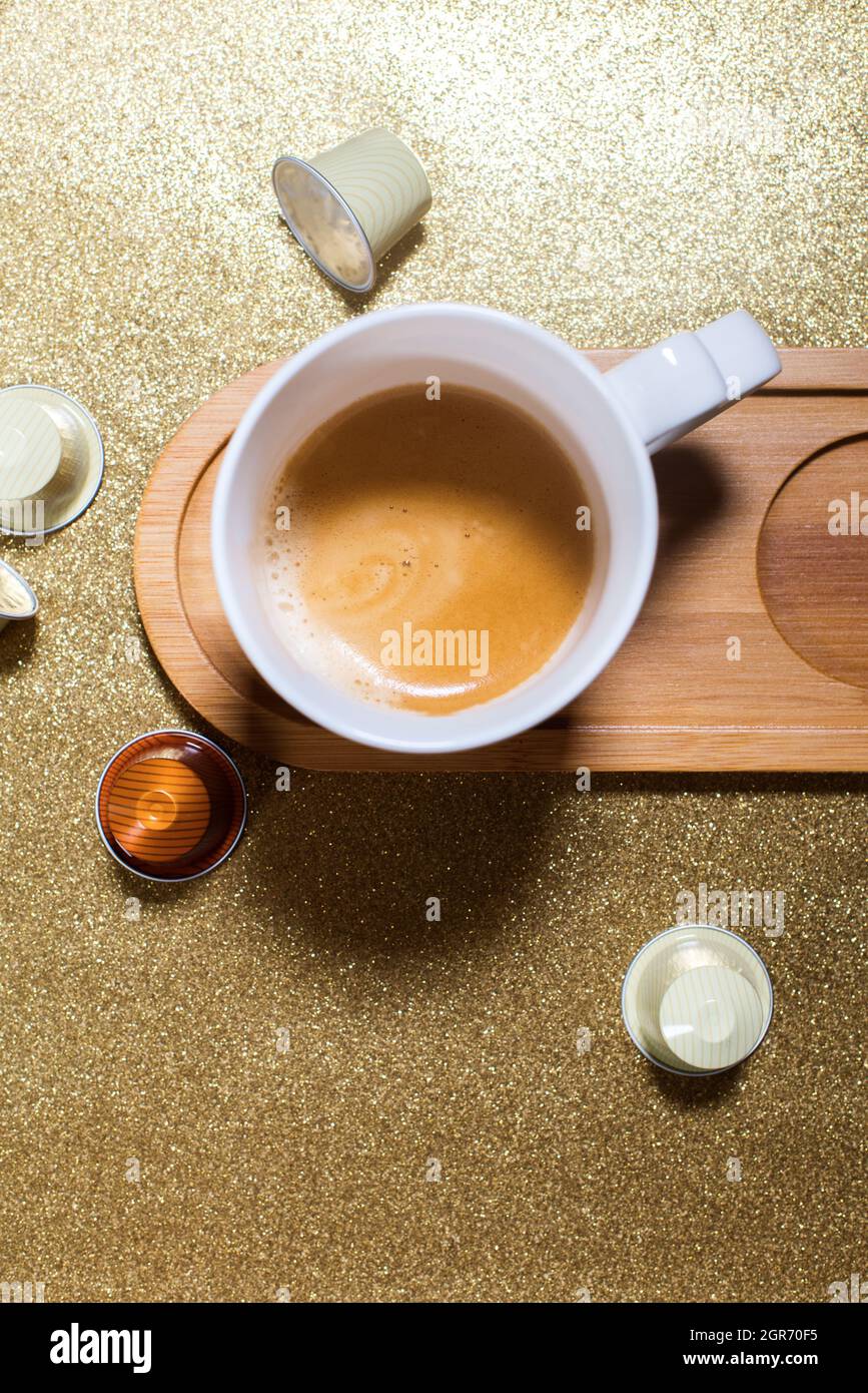 Taza de café espresso con leche y cápsulas frescas en papel brillante de  color dorado. Minimalismo Fotografía de stock - Alamy