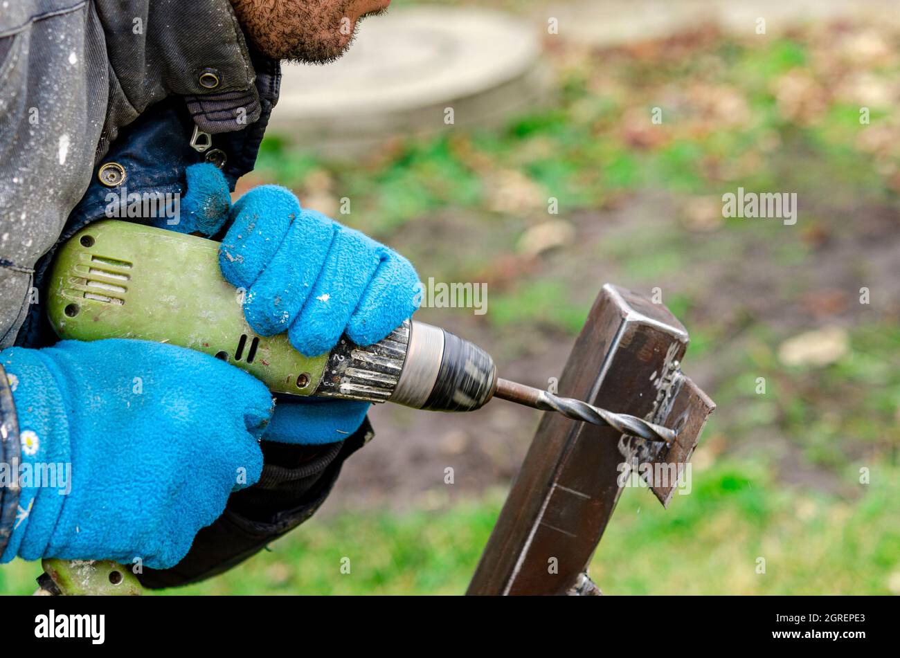 Taladro destornillador flujo de trabajo creación de piezas de metal. Hombre  trabajador de metal utilizando prensa perforadora. Imagen tonificada. Desde  la vista lateral Fotografía de stock - Alamy