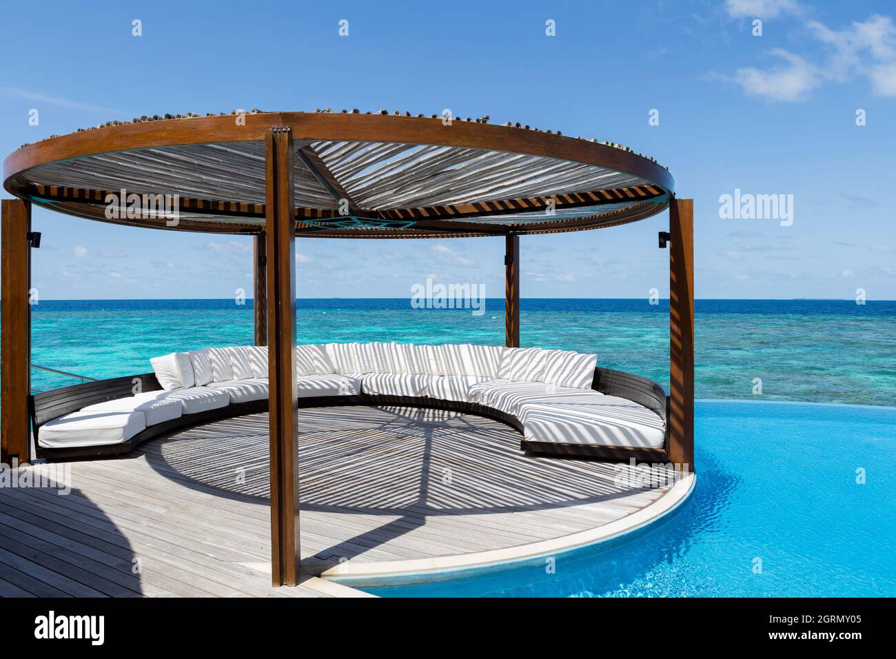La zona de estar exterior con piscina y el mar real en Maldivas Foto de stock