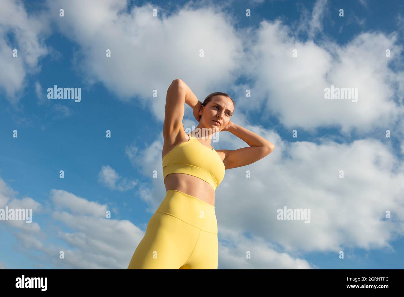 Deportista y deportiva joven atleta con fondo de cielo azul. El concepto de un estilo de vida y un deporte saludables. Foto de stock