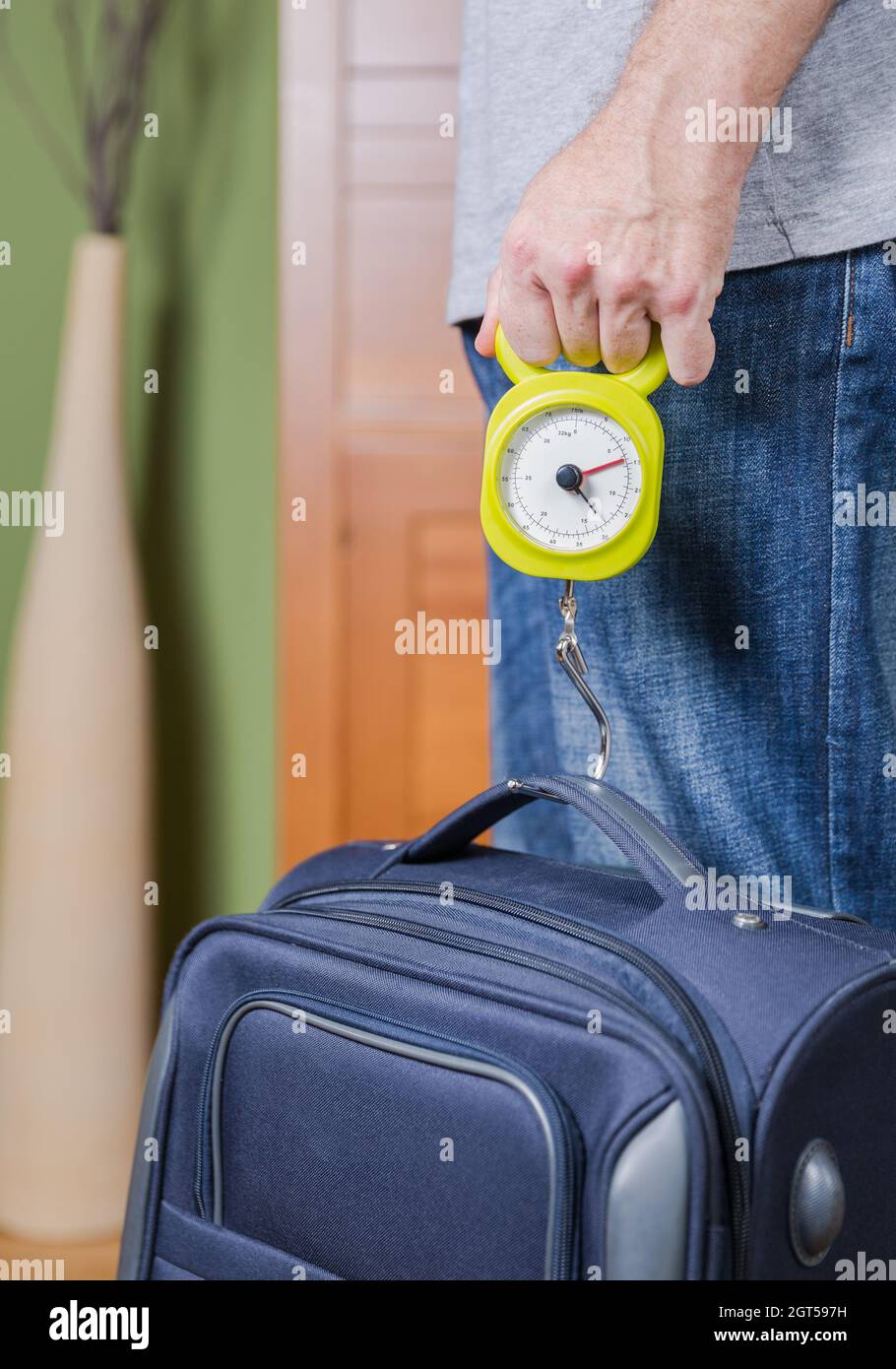 Sección media del hombre que mide el peso de la maleta en el hogar  Fotografía de stock - Alamy