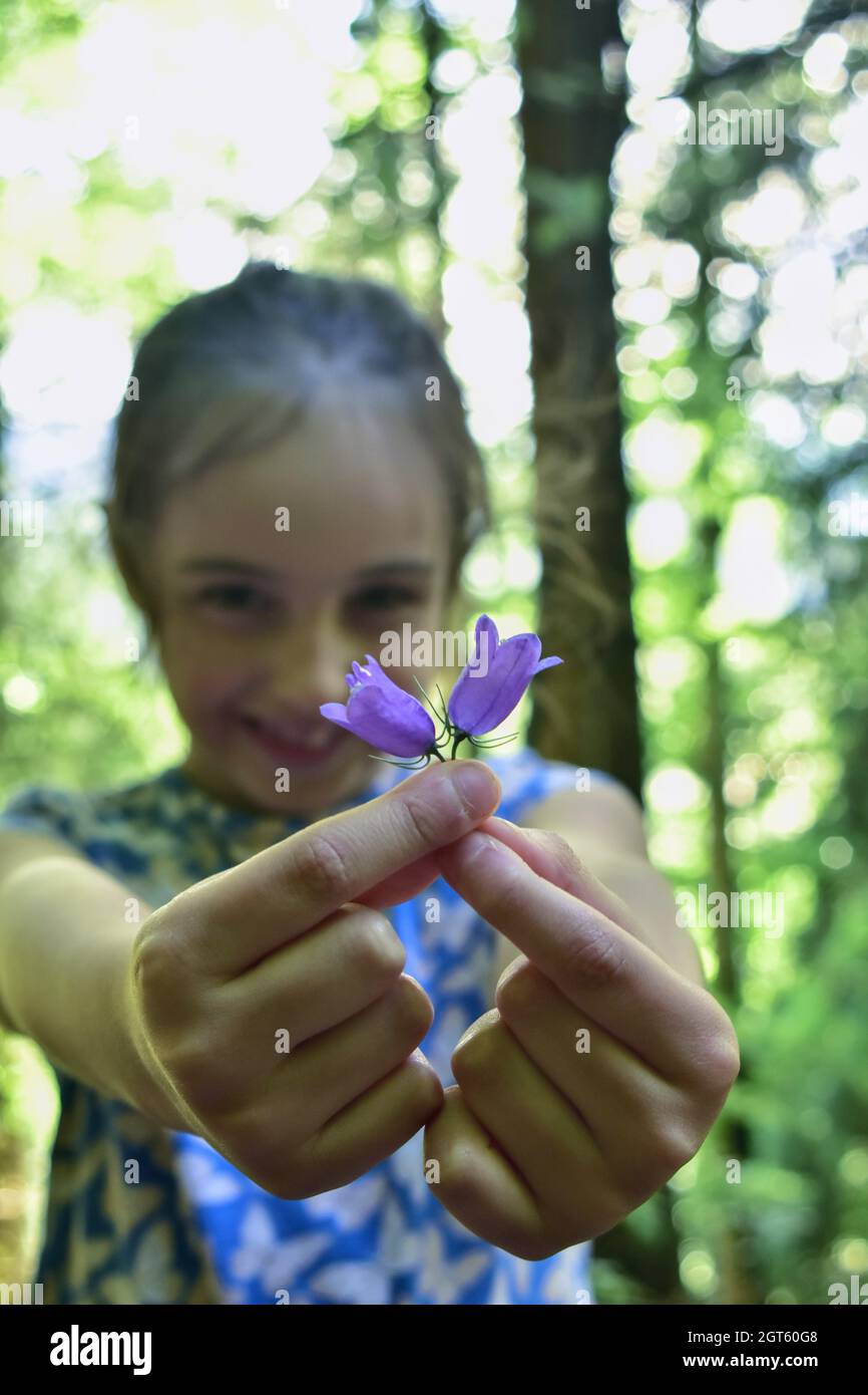 Retrato de la niña sosteniendo la flor púrpura Foto de stock