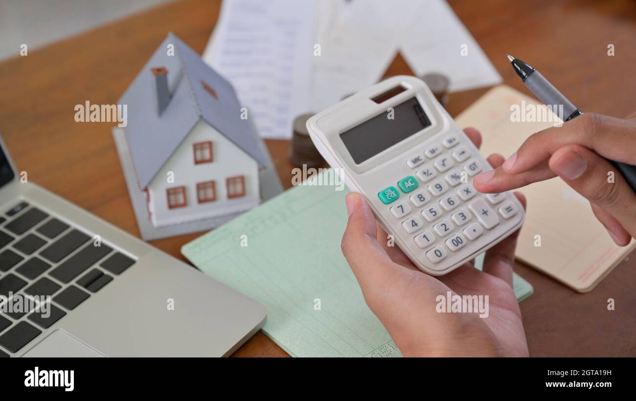 El propietario de una casa utiliza la calculadora para verificar los gastos  de la casa Fotografía de stock - Alamy
