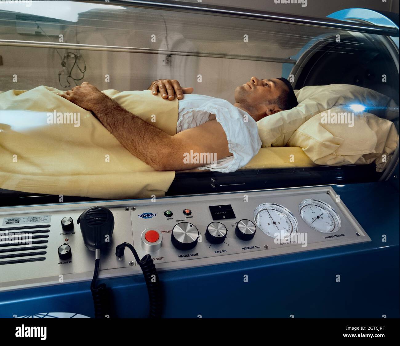 Paciente sometido a oxigenoterapia hiperbárica en una cámara de un solo paciente presurizada. Foto de stock
