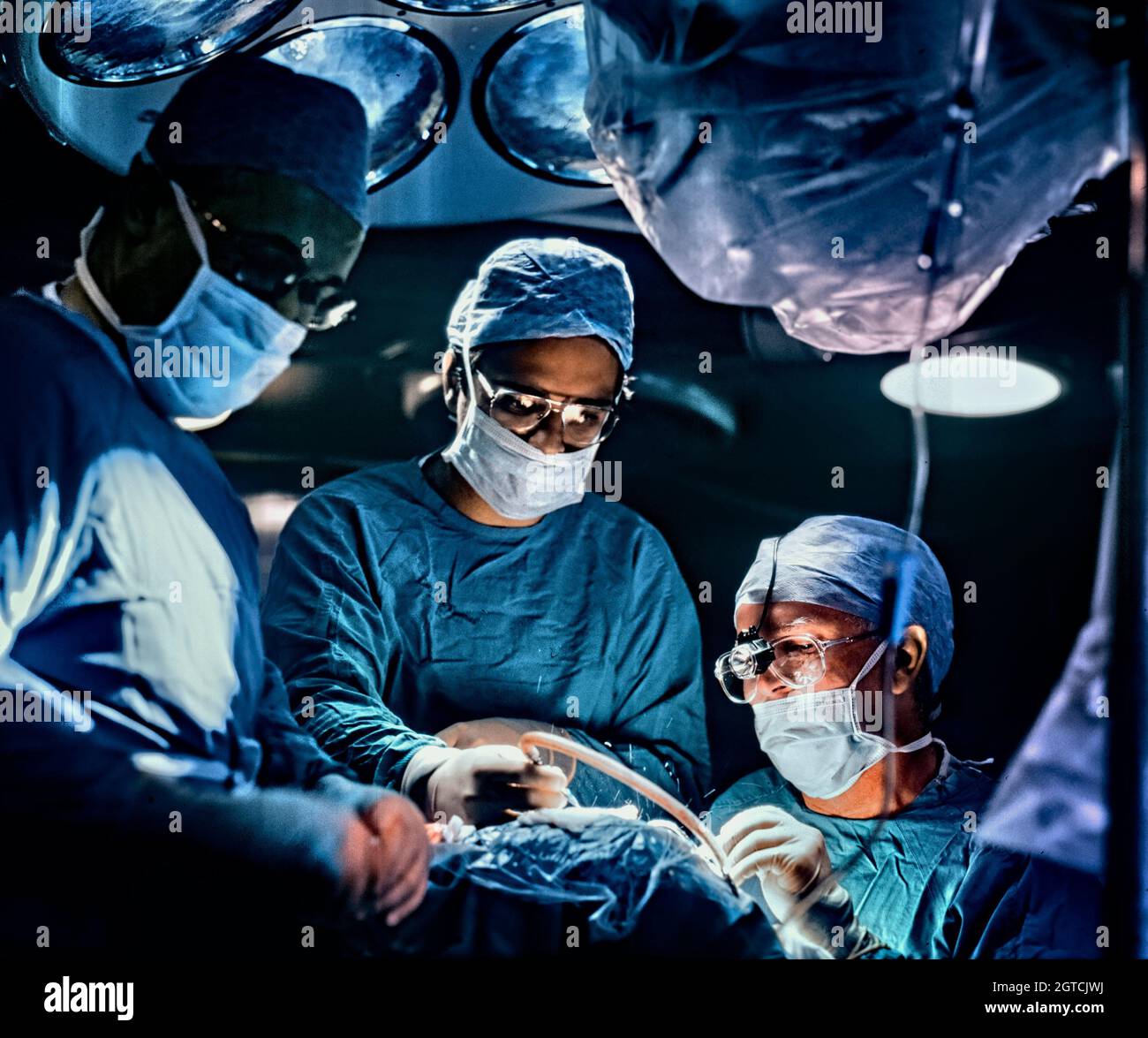 Cirujanos que trabajan en la implantación de un implante coclear en el cráneo de un paciente. Foto de stock