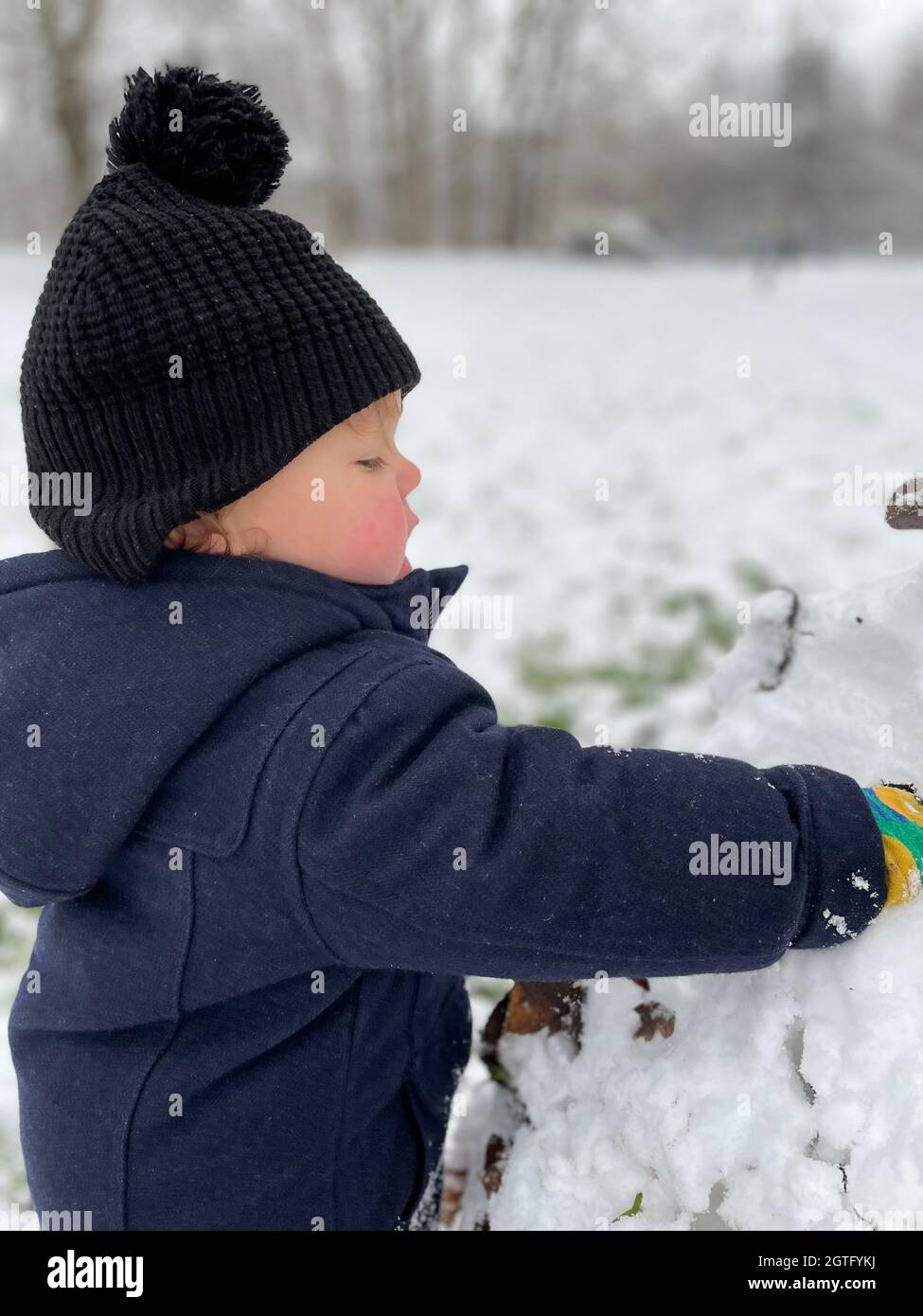 Vista lateral del niño jugando con la nieve durante el invierno al aire  libre Fotografía de stock - Alamy