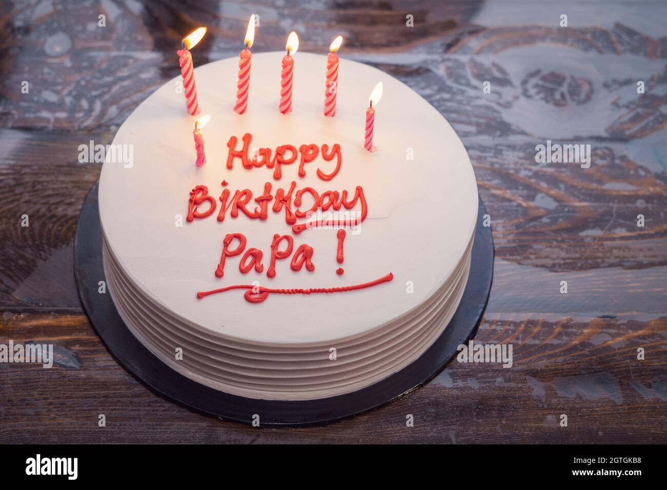 Pastel para papá escribió Feliz cumpleaños Papa. Vela ardiente en la torta  Fotografía de stock - Alamy
