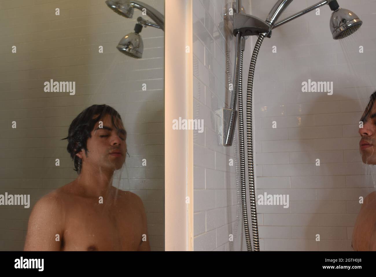 Hombre joven mirando en la ducha Fotografía de stock - Alamy