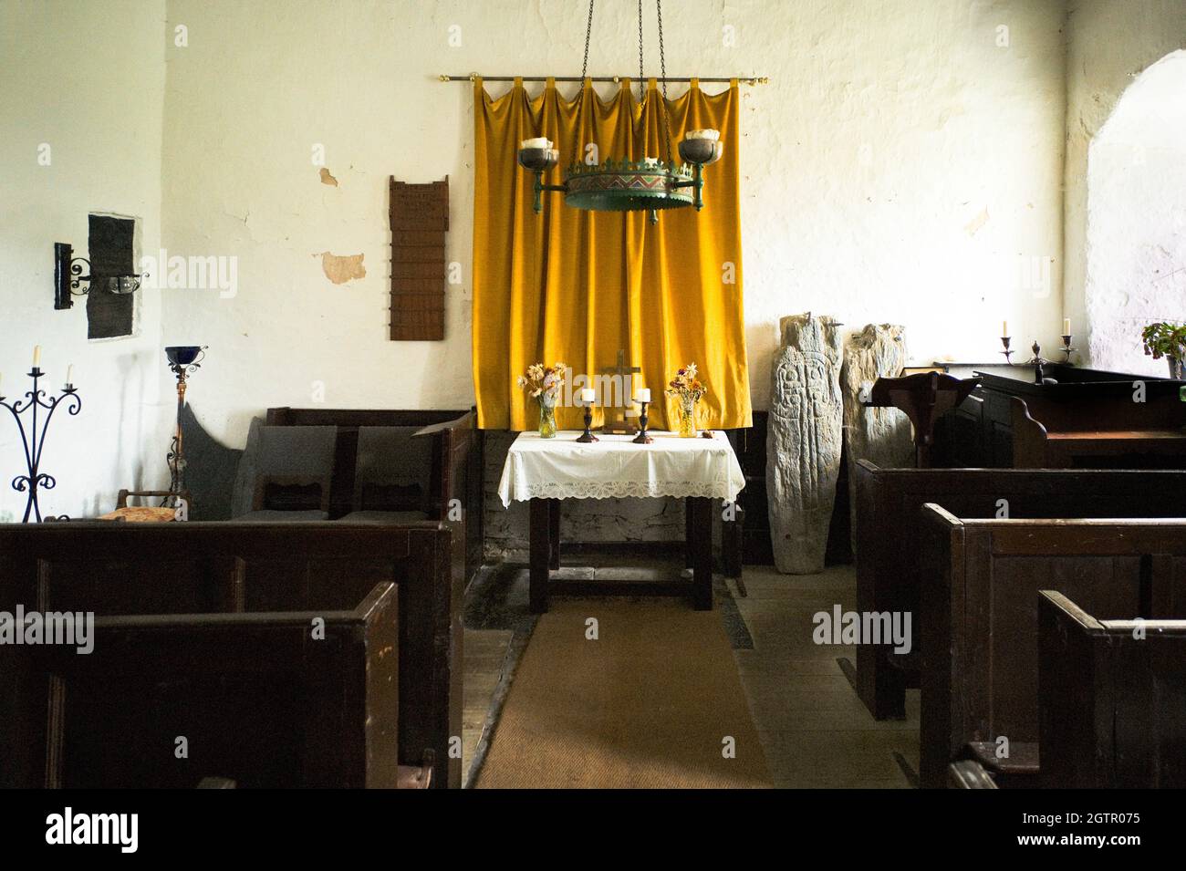 Interior de la pequeña capilla de San Runius cerca de Colby, Isla de Man con dos cruces celtas cerca del altar. Esta capilla no tiene suministro eléctrico Foto de stock