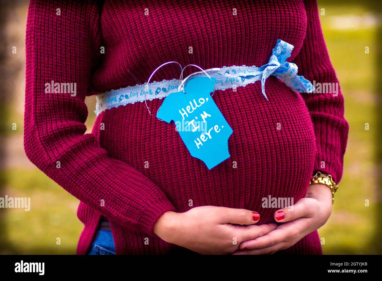 Sección media de la mujer embarazada Estómago con cinta y etiqueta al aire libre Foto de stock