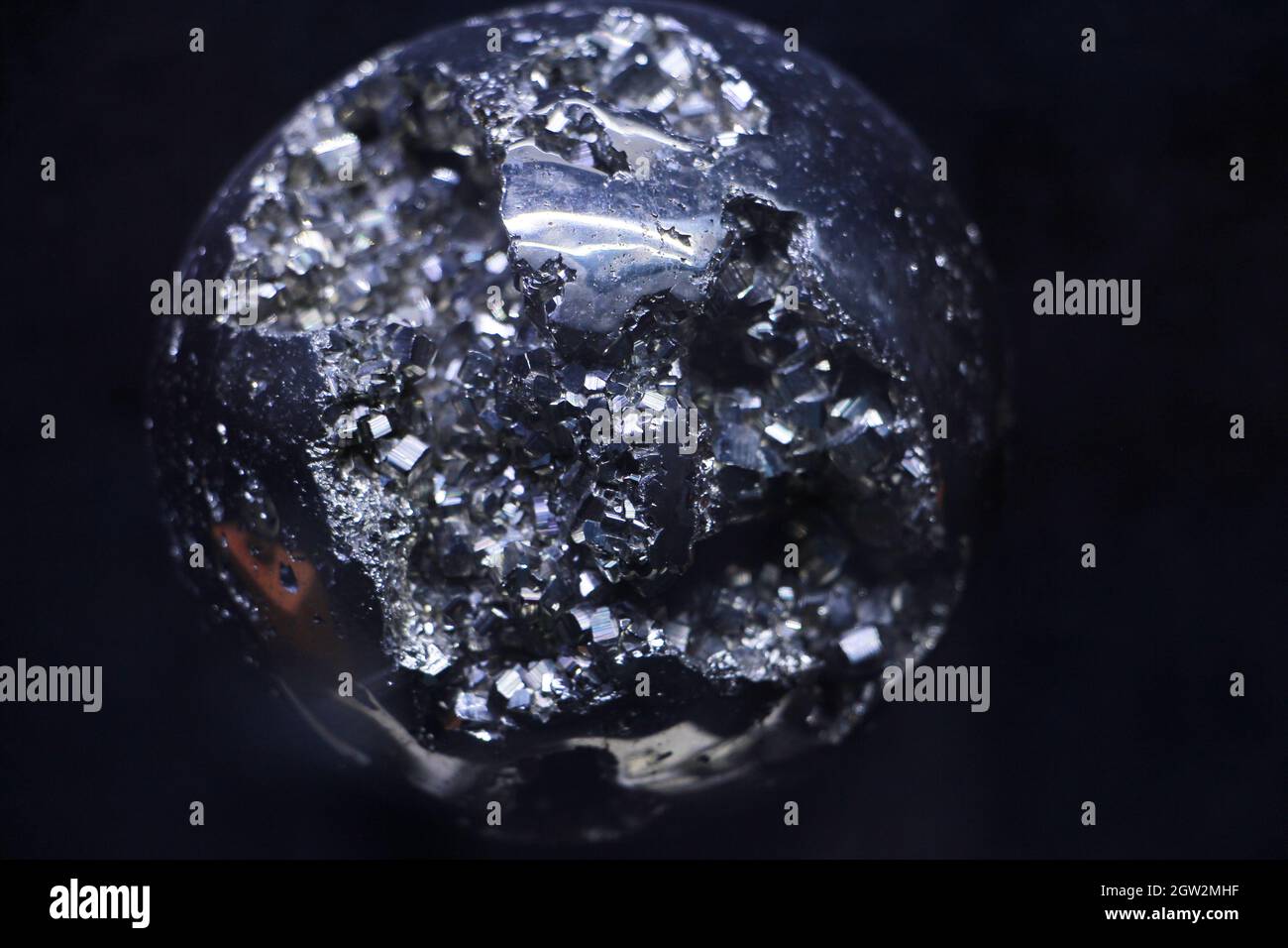 Primer plano de la bola metálica contra fondo negro Foto de stock
