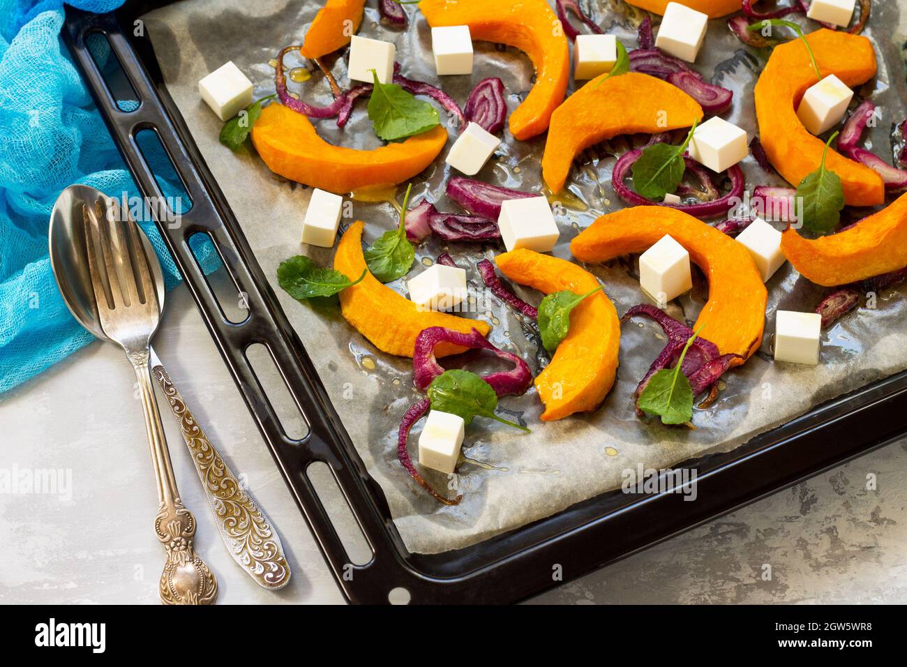 Rebanadas de calabaza al horno con cebolla, servidas con queso Feta, rúcula  y semillas de calabaza Fotografía de stock - Alamy