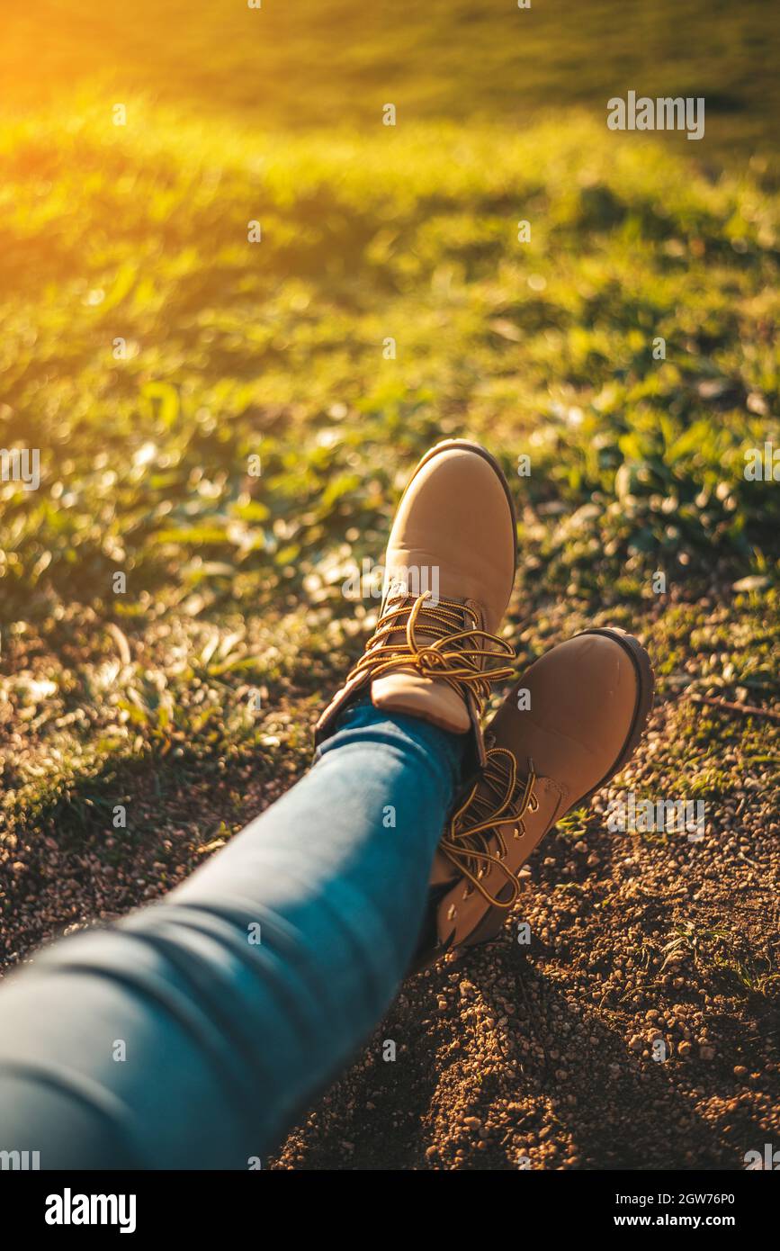 Sección baja de la mujer usando zapatos relajándose en el campo Fotografía  de stock - Alamy