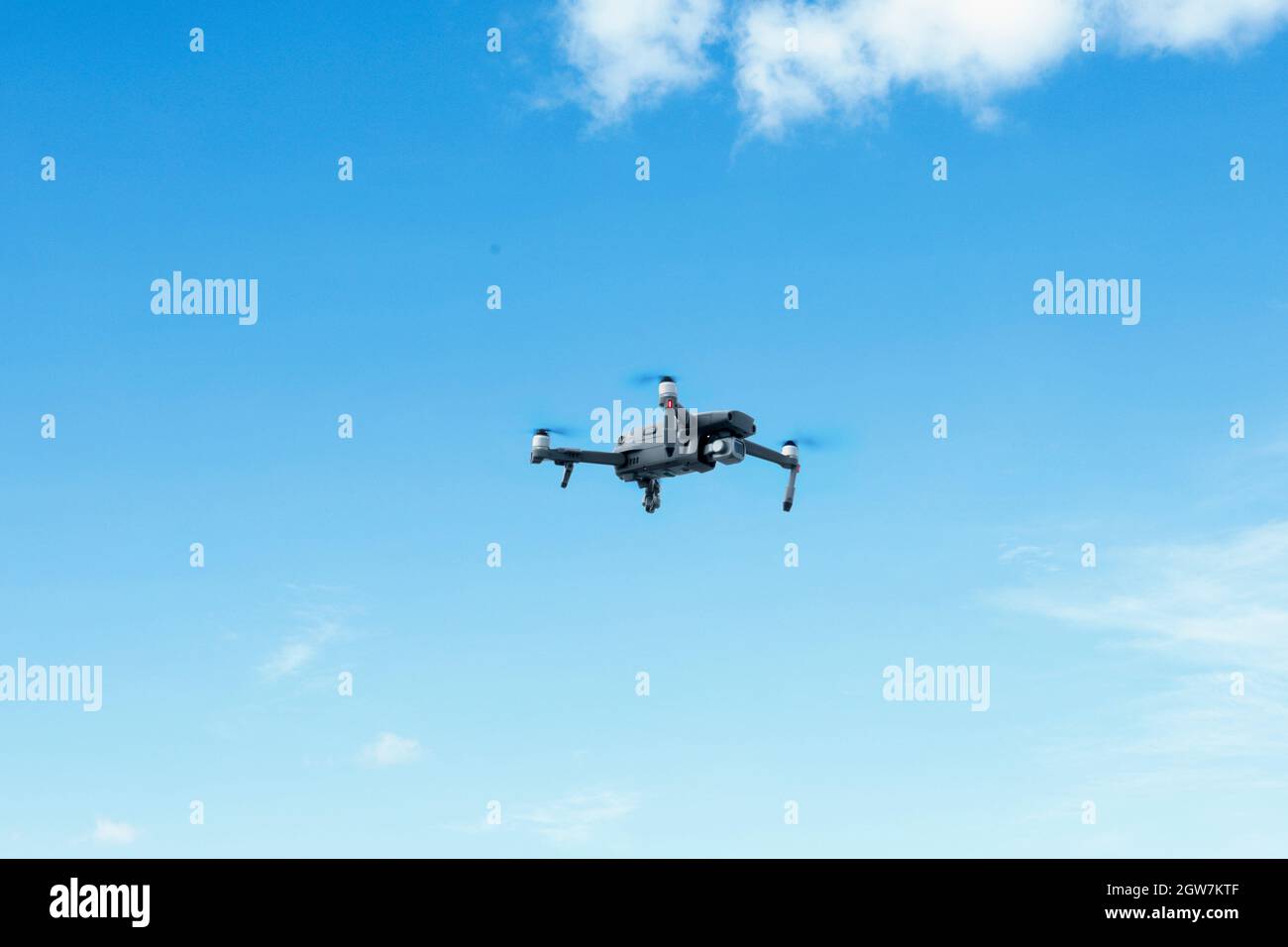 Ángulo de visión baja de Drone volando contra el cielo azul Foto de stock