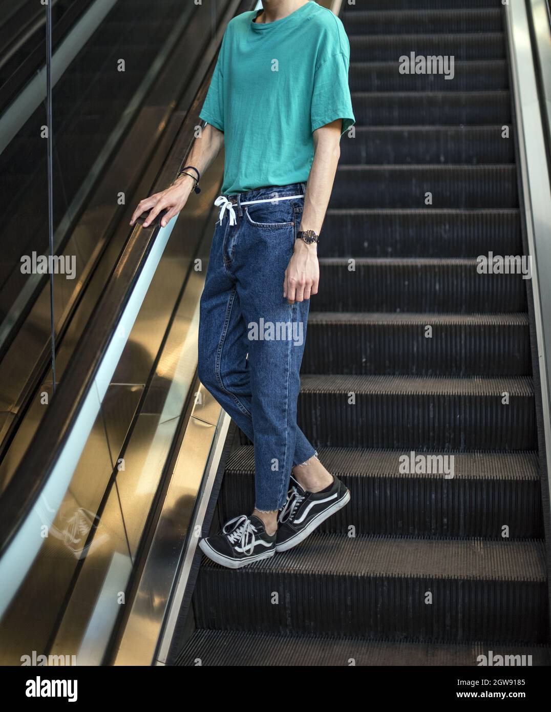 Hombre joven con zapatos de piel vieja Vans en escaleras mecánicas en el  centro comercial Fotografía de stock - Alamy