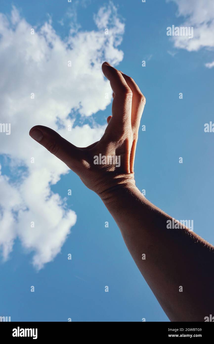 Mano tocando las nubes en el cielo azul Fotografía de stock - Alamy