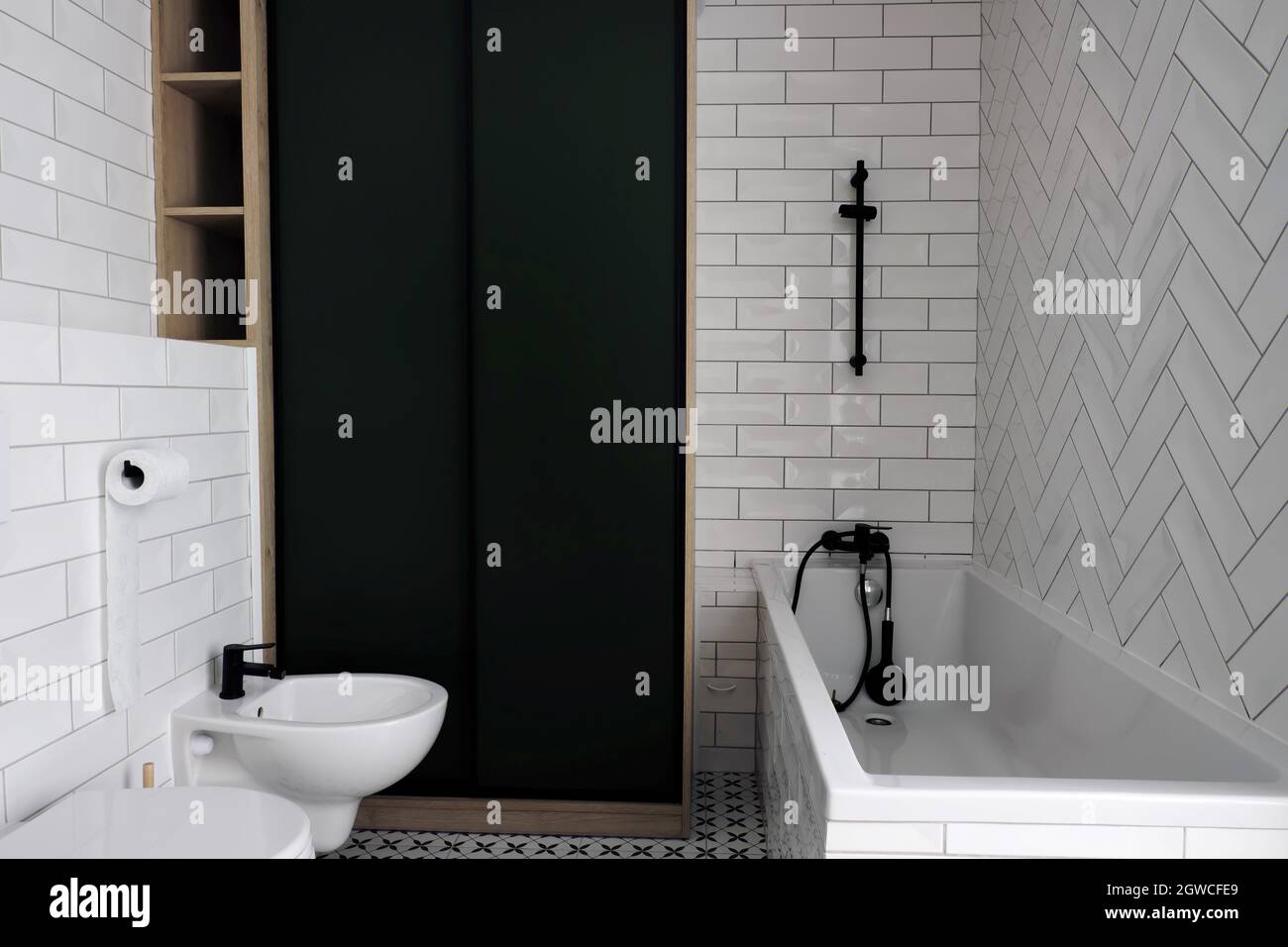 Moderno lavabo de baño blanco con grifo negro y azulejos blancos y negros  Fotografía de stock - Alamy