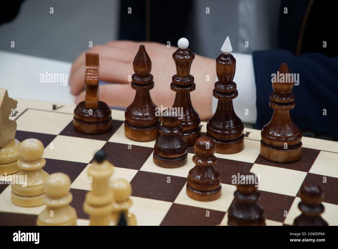 Mano de hombre recortada por piezas de ajedrez en mesa Foto de stock