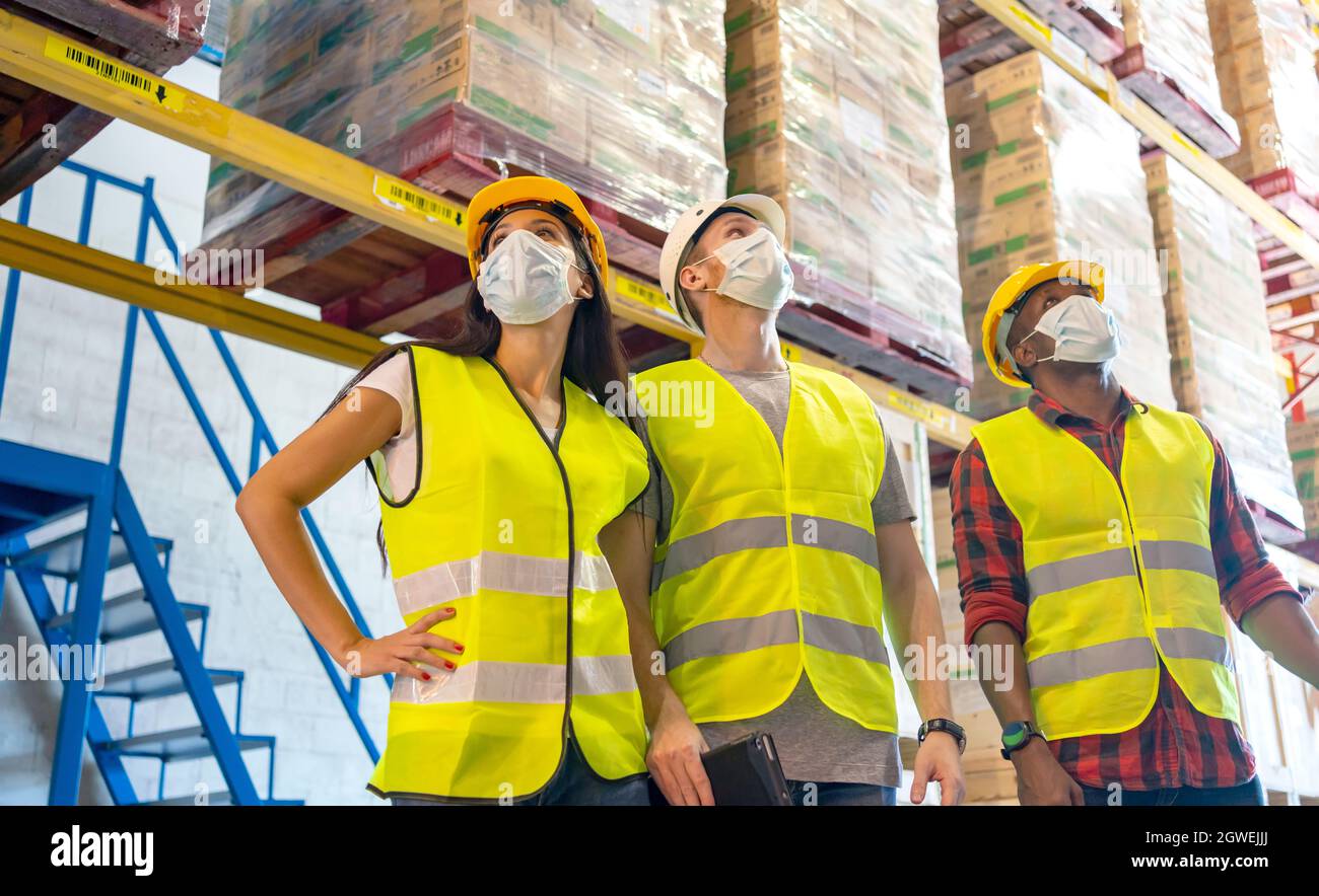 Compañeros de trabajo que llevan ropa de trabajo de protección mientras  están de pie al aire libre Fotografía de stock - Alamy
