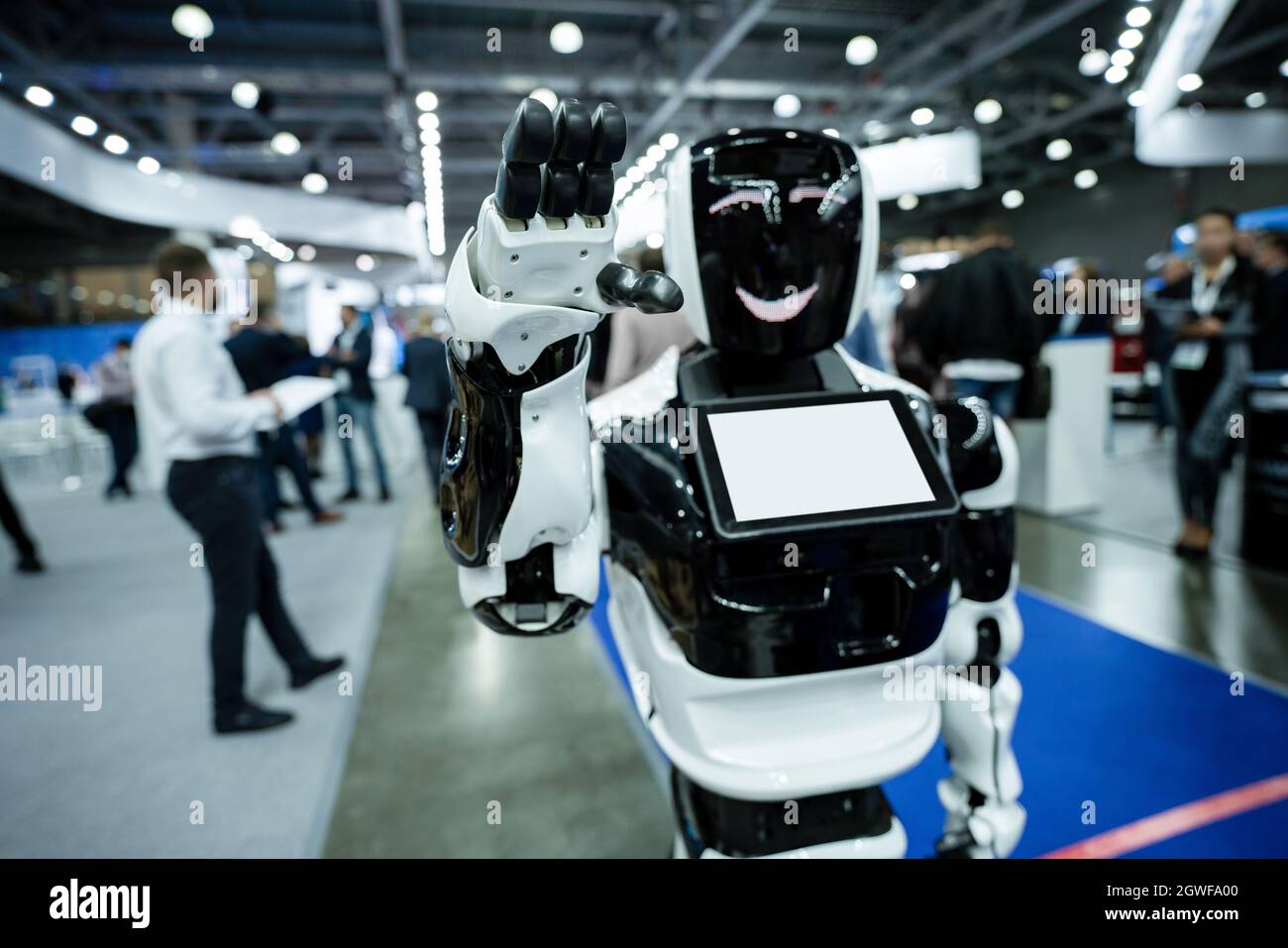 Robot de promoción con pantalla táctil saluda agitando la mano Foto de stock