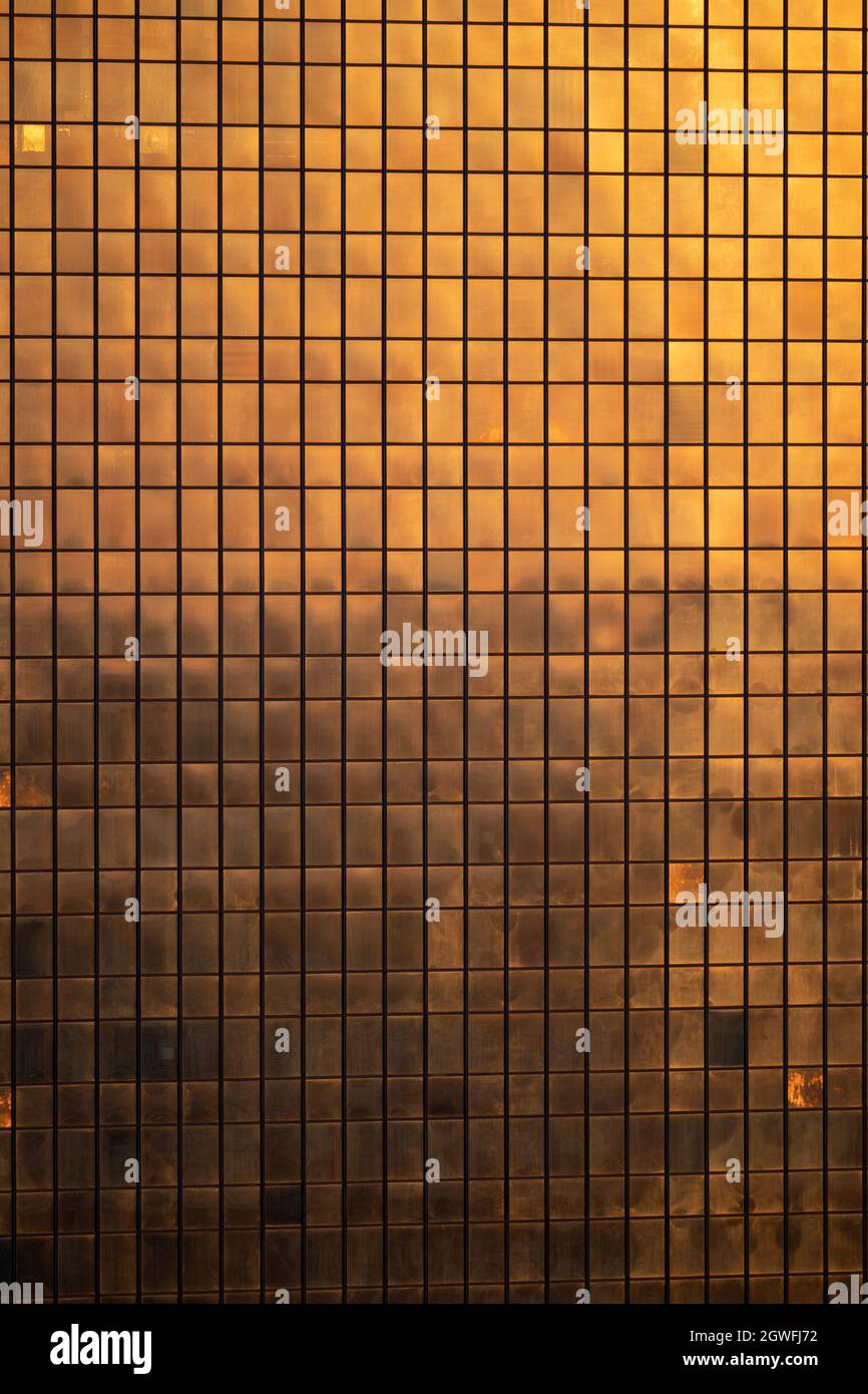 Ventanas del edificio rascacielos al atardecer, fachada de vidrio del edificio moderno iluminada por el color dorado del sol, Marriott Hotel, Polonia. Foto de stock