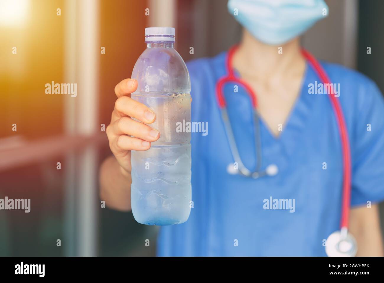 Enfermera del doctor Dando o recomienda beber agua fresca limpia en verano caliente para prevenir la deshidratación. Foto de stock