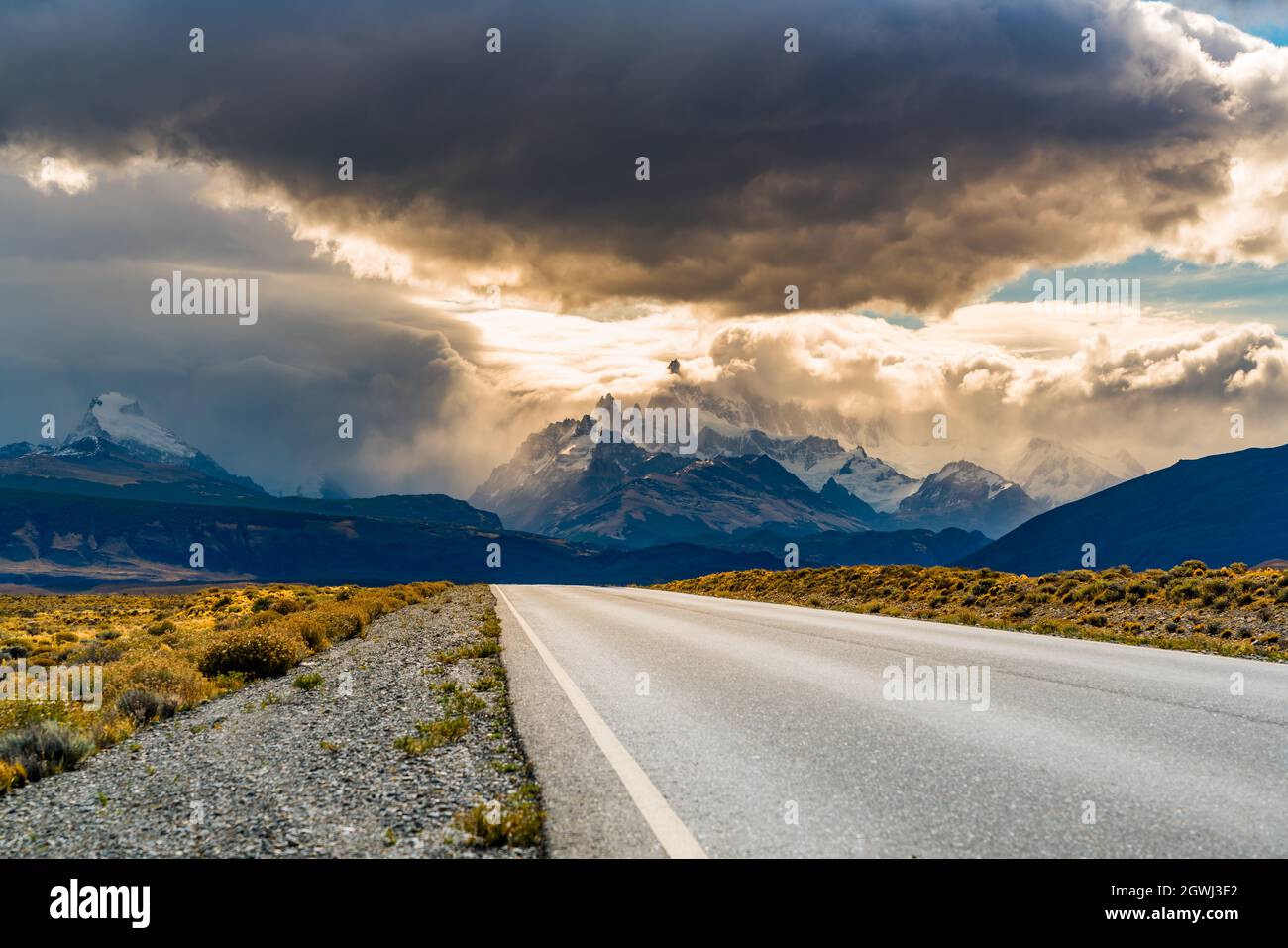 La carretera que conduce hacia las montañas contra el cielo Foto de stock