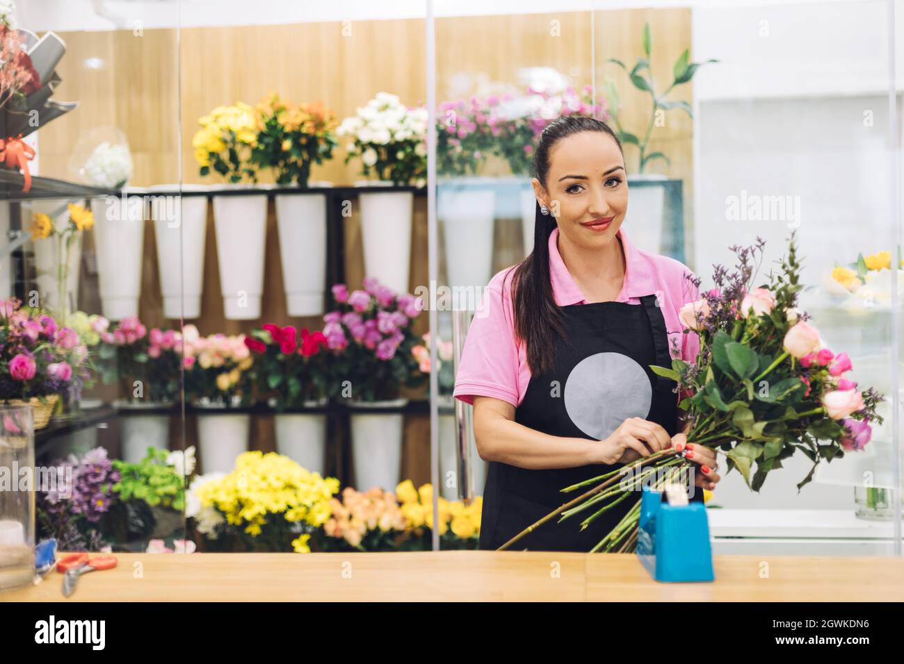 Una florería joven atractiva trabaja en una tienda de la flor y hace  arreglos de la flor para la venta Fotografía de stock - Alamy