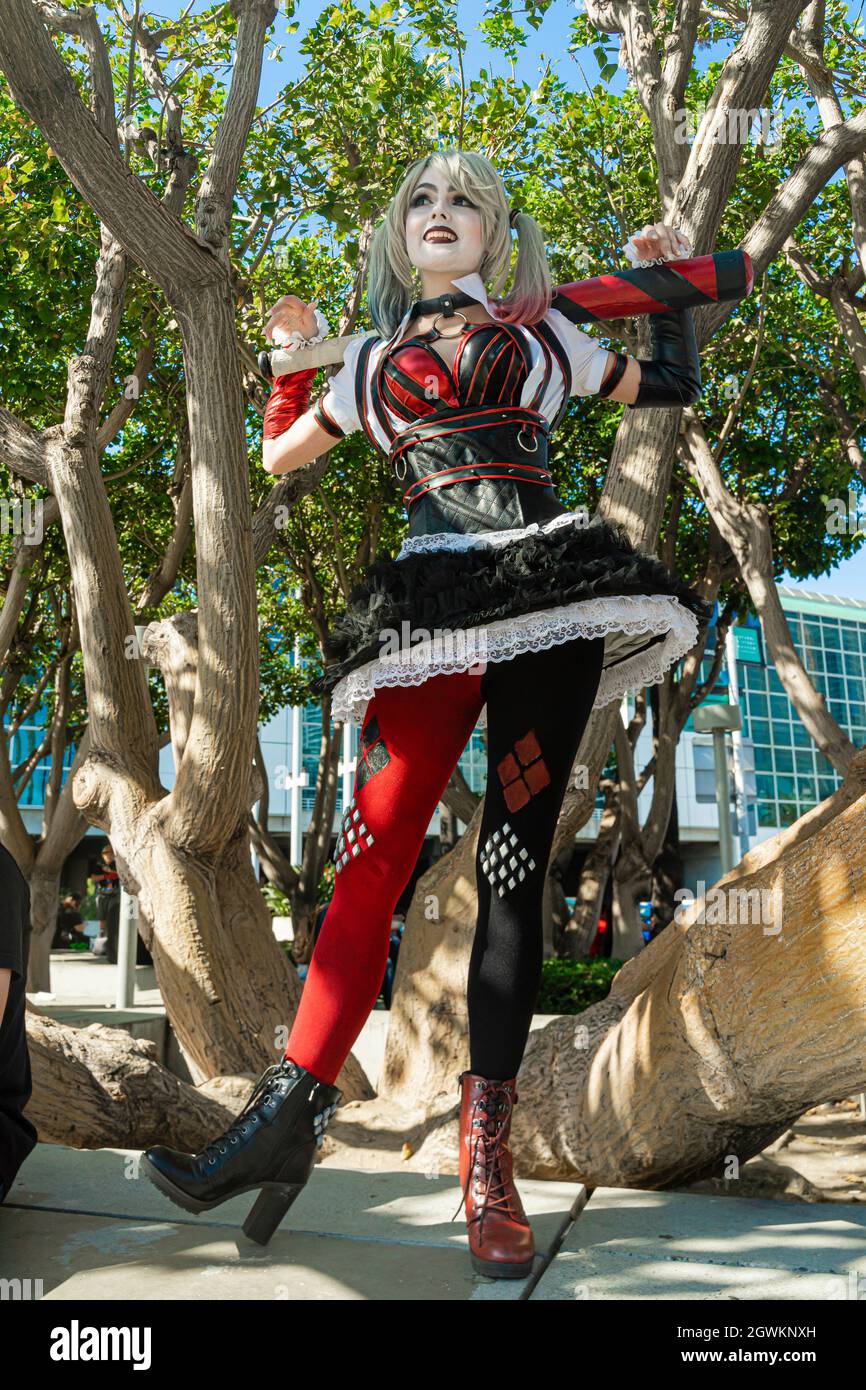 Chica en traje de Harley Quinn. Ella se levanta con un bate y lame el bat.  Cerca. Cosplay Fotografía de stock - Alamy