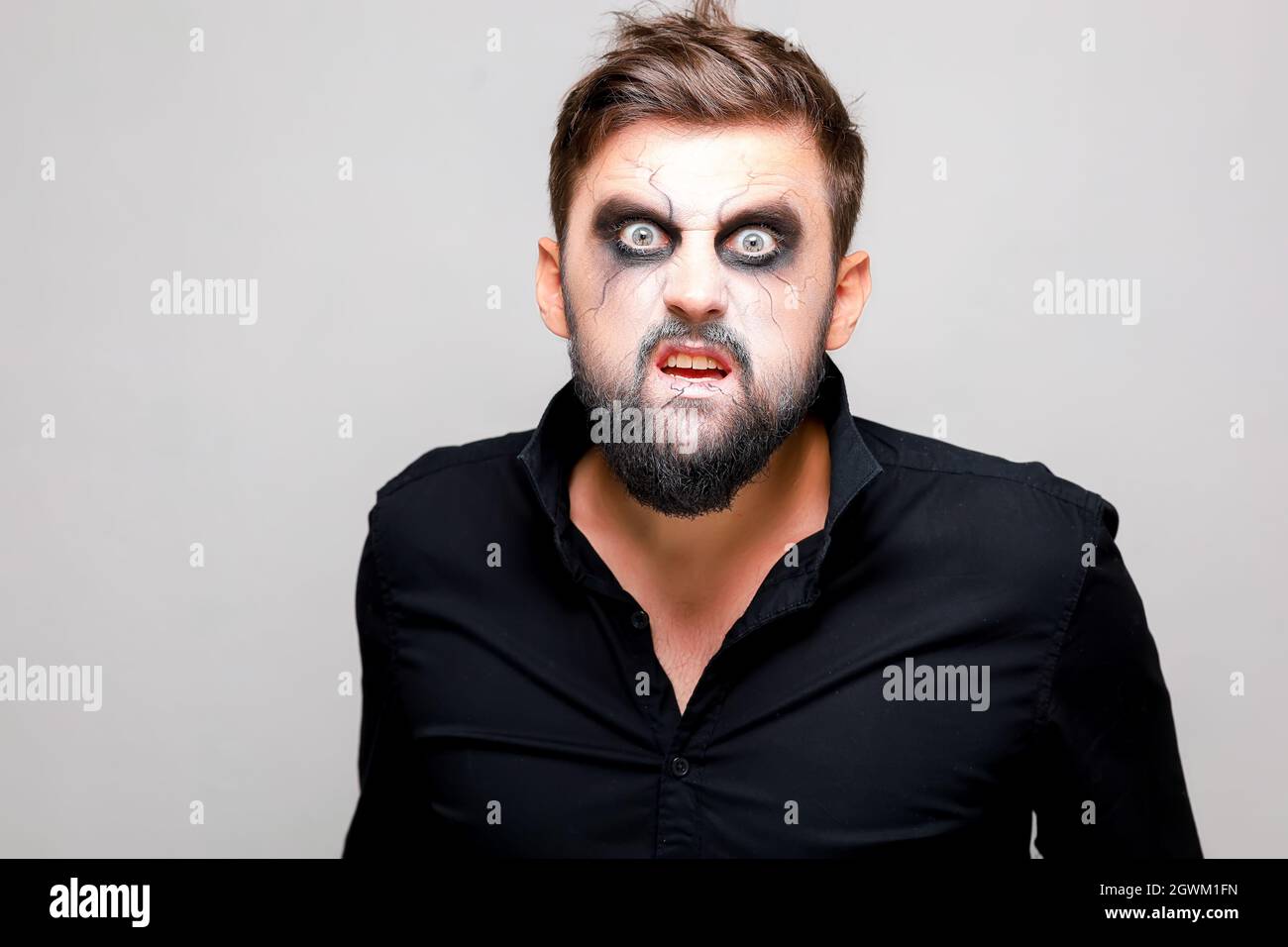 Un hombre con barba y maquillaje al estilo de los muertos vivientes en  Halloween abrió la boca y muestra sus dientes Fotografía de stock - Alamy