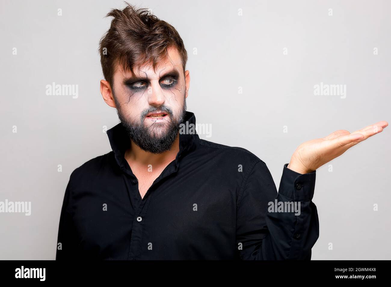 Un hombre con una barba y maquillaje sin vida en Halloween tiene sus manos  delante de él Fotografía de stock - Alamy