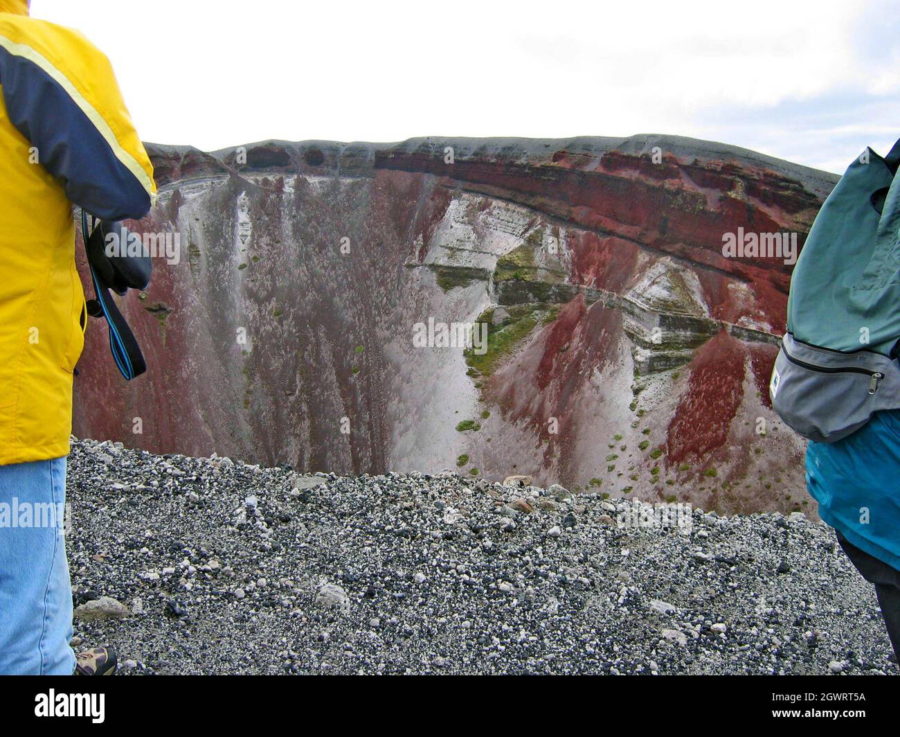 Los visitantes se encuentran en lo alto del Monte Tarawera, un volcán inactivo conocido por su erupción de 1886. Situado en la región de la Bahía de Plenty, en la zona volcánica de Taupo, las paredes del volcán de fisura de los acantilados de scoria roja que se desmoronan ofrecen un paisaje surrealista mientras los visitantes caminan por los acantilados quemados llenos de gritos. Foto de stock