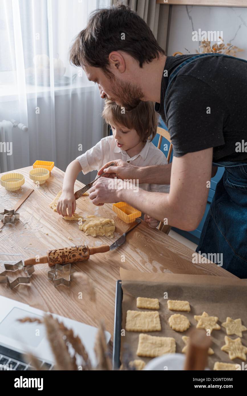 Lindo niño de preescolar y su padre que coje galletas para el Día Internacional del Espacio usando lección de video Fotografía de stock - Alamy Lindo niño de preescolar y su padre que coje galletas para el Día Internacional del Espacio usando lección de video Fotografía de stock - Alamy