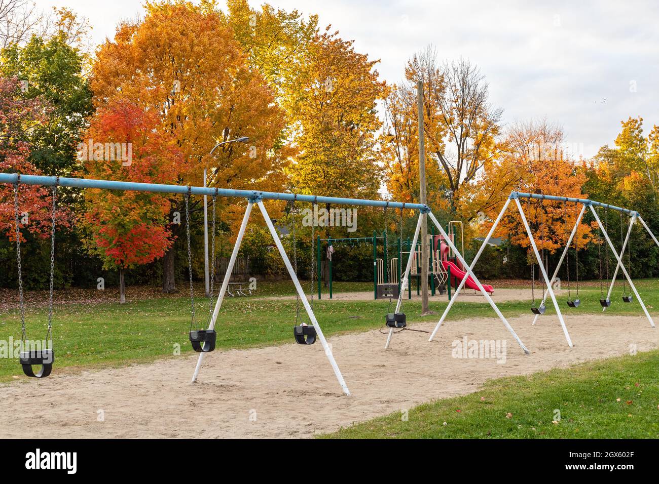 Parque público con parque infantil en otoño con columpios y hermosos  árboles en el fondo. Temporada de otoño Fotografía de stock - Alamy