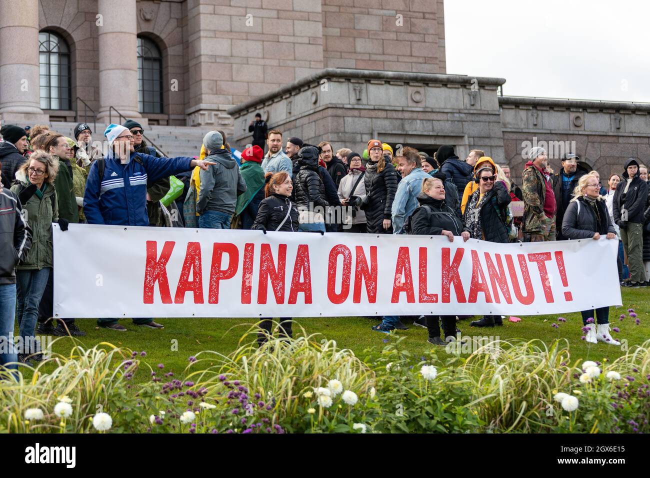 Manifestantes sosteniendo 'Kapina en alcanut!' Bandera en frente de la Casa del Parlamento en Helsinki, Finlandia Foto de stock