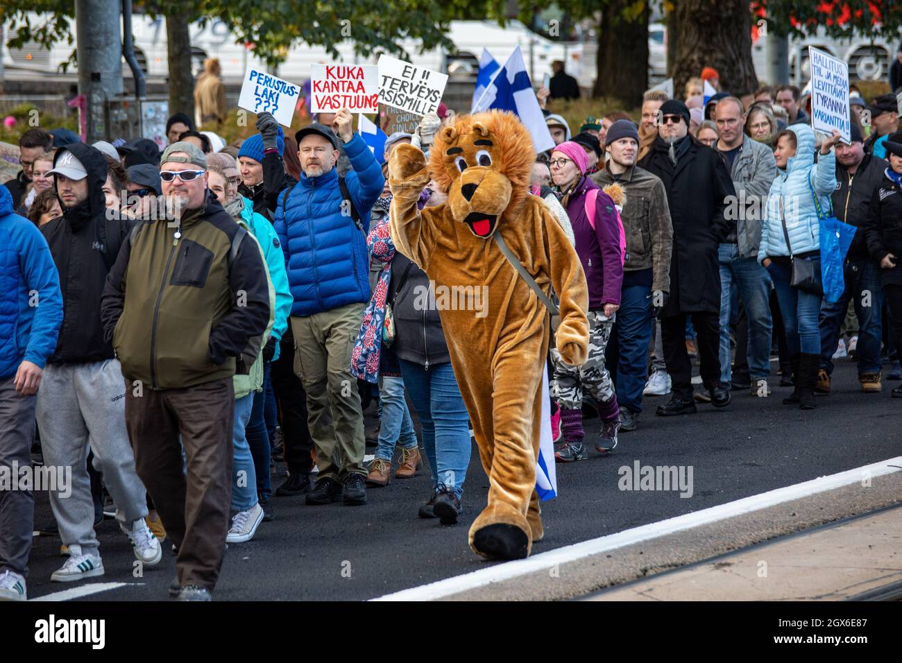 Mascota de león marchando con manifestantes contra la vacuna contra el coronavirus en Helsinki, Finlandia Foto de stock