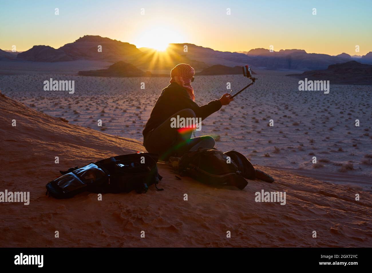 mujer irreconocible haciendo una foto mientras se pone el sol en el  desierto de ron wadi Fotografía de stock - Alamy