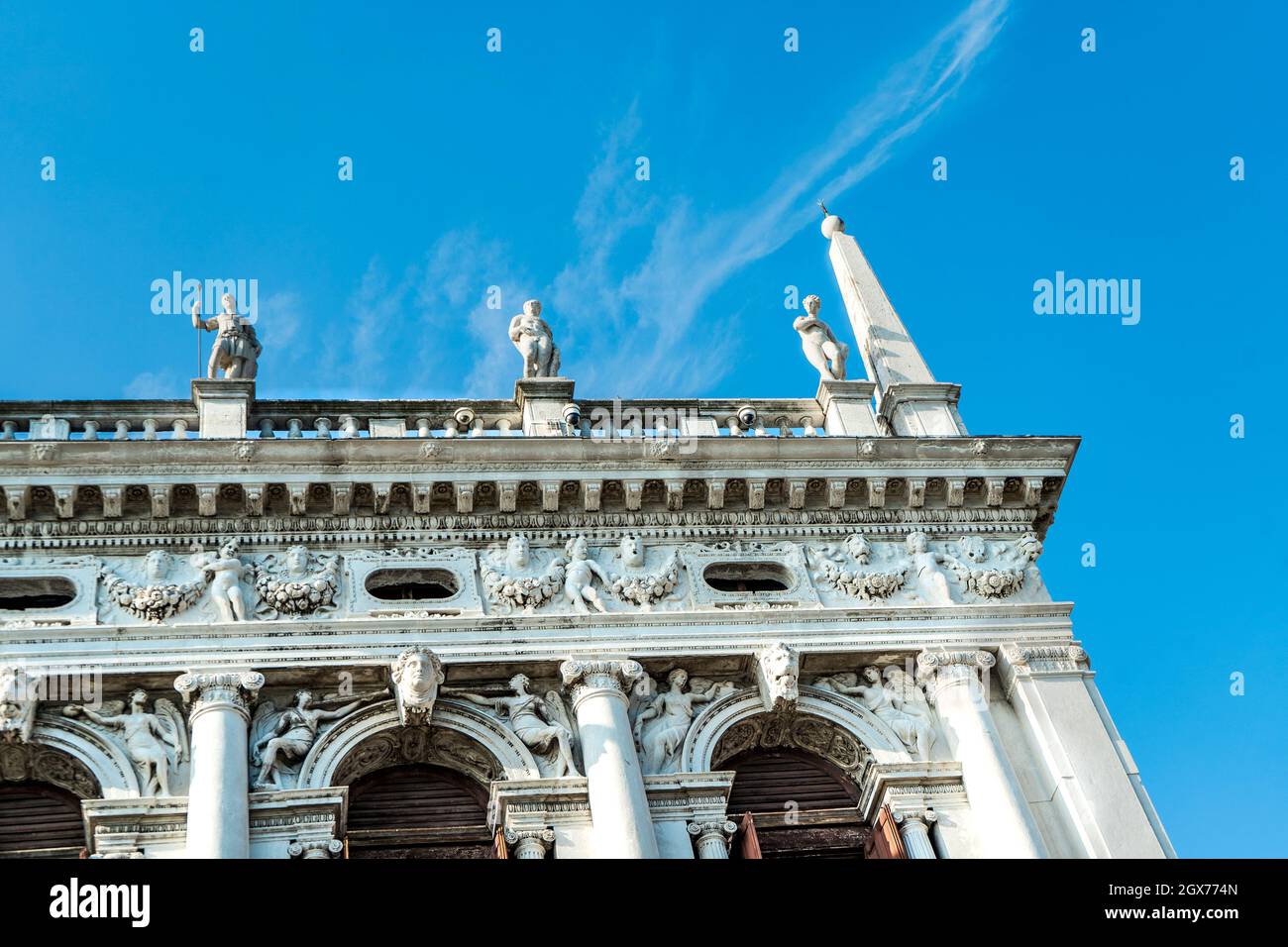 Detalle del edificio exterior de la Biblioteca Nacional Marciana con estatuas de mármol y relieves bajo, en la plaza de San Marcos, Venecia, Italia Foto de stock