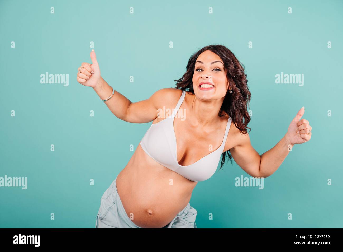 Mujer embarazada feliz esperando un niño acaricia su vientre Foto de stock