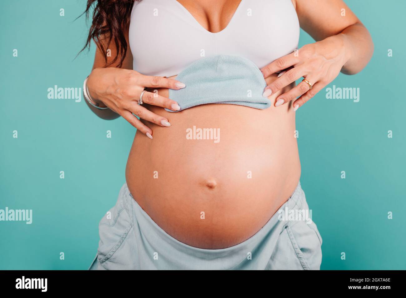 La madre embarazada prepara la ropa para el bebé Foto de stock