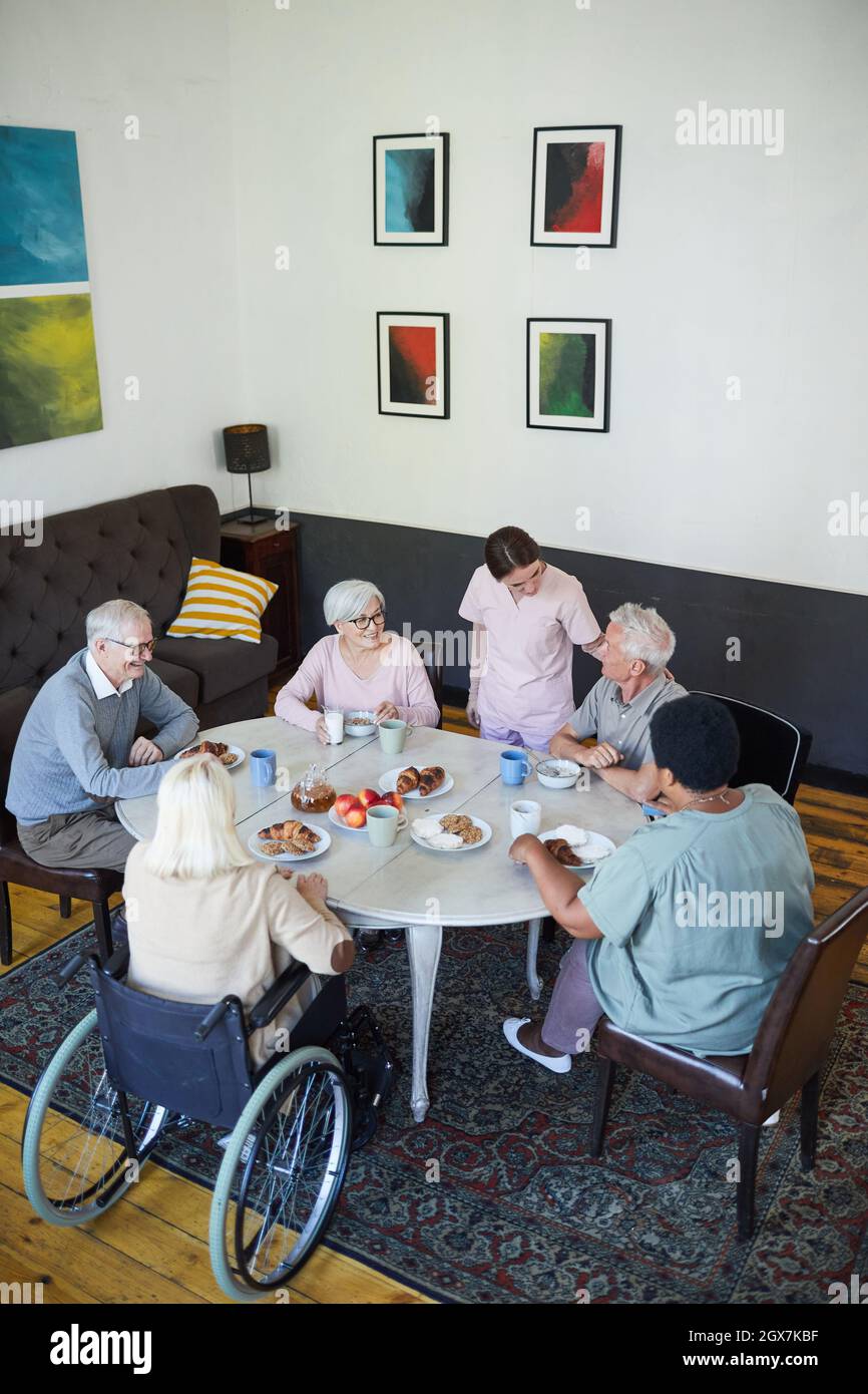 Vista vertical de alto ángulo en diversos grupos de personas mayores  disfrutando del desayuno en la mesa de comedor en la residencia de ancianos,  espacio de copia Fotografía de stock - Alamy