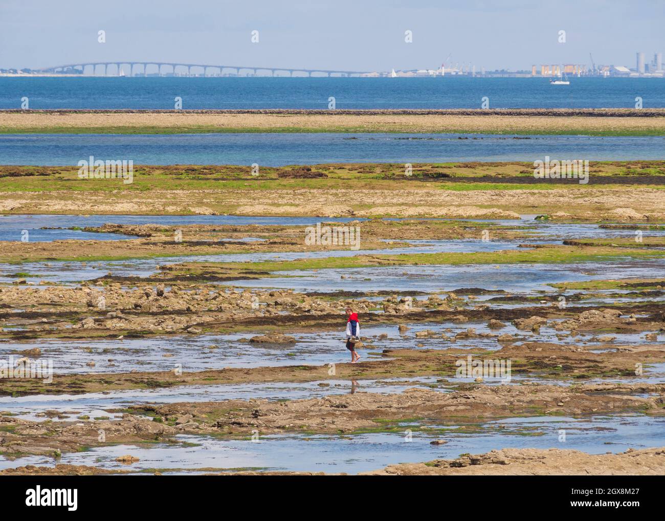 Pointe de Chassiron en la marea baja, Ile d'Oléron, Charente Maritime, France.In la distancia La Rochelle y el puente de Ile de Ré. Foto de stock